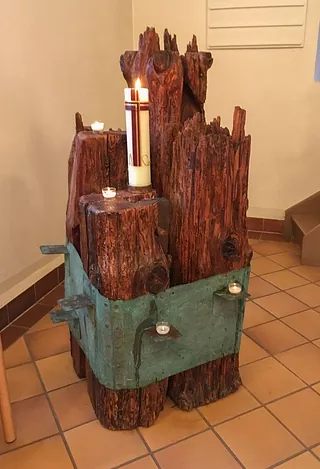 Balken aus der alten Dorfkirche Alt-Wittenau mit Osterkerze und Teelichtern