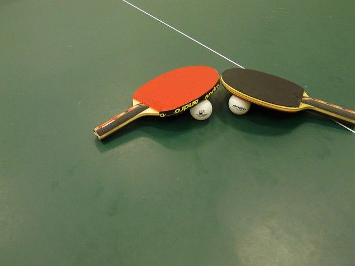 Zwei Tischtennisschläger auf 2 Bällen